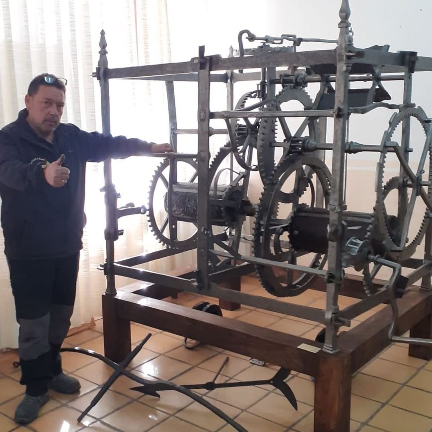 Maestro relojero de Relojes de Torre López frente a un reloj de torre